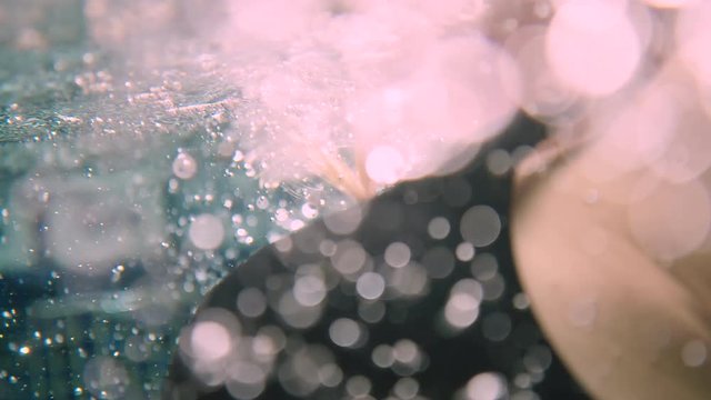 Stunning cinematic sixty frames per second slow motion shot of a pregnant woman underwater