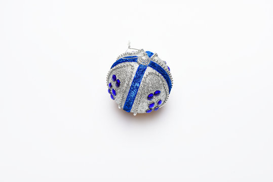 Festive decoration for Christmas tree, silver ball with blue rhinestones, isolated on white background. Christmas decoration or toy for Christmas tree with silver shimmering surface. Ornament concept