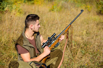 Man charging hunting rifle. Hunting equipment concept. Hunting hobby and leisure. Hunter with rifle looking for animal. Hunter khaki clothes ready to hunt nature background. Hunting shooting trophy