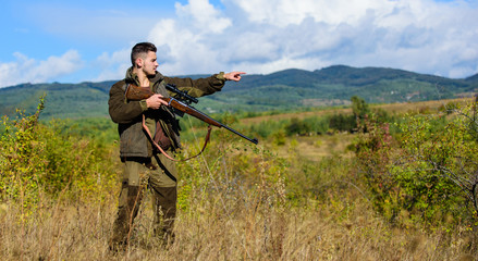 Man hunter aiming rifle nature background. Experience and practice lends success hunting. Guy hunting nature environment. Hunting weapon gun or rifle. Masculine hobby activity. Hunting target