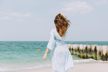 Fototapeta na wymiar Young woman walking along the beach in Dubai