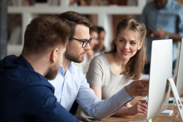 Diverse millennial employees coworking discussing business project or idea in shared office,...