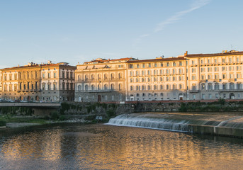 Fototapeta na wymiar Old dam across the Arno river in Florence, Italy