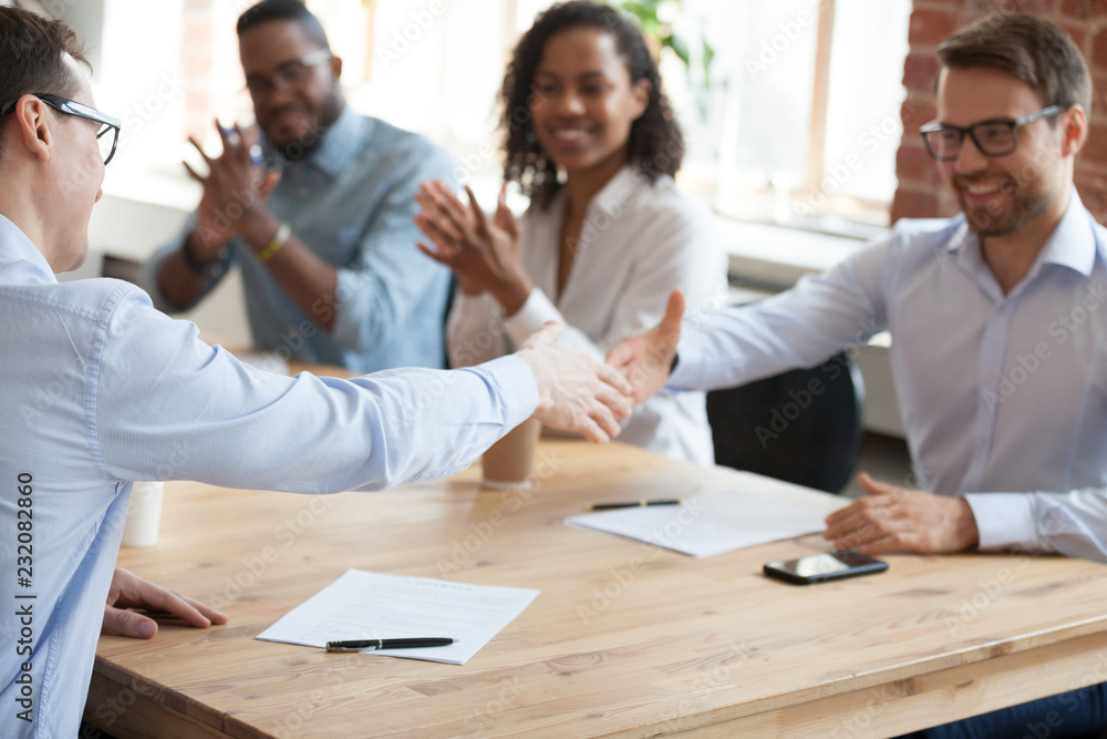 Poster Smiling business partners shake hands after successful negotiations in office, excited male workers handshake greeting with employment, happy employees get acquainted at meeting. Partnership concept