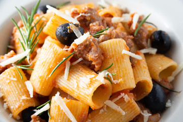 Piatto di mezze maniche con salsiccia, olive e formaggio