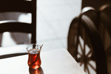 typical glass of tea on the table outside on the street in a sunny day - copy space ritual in istanbul.