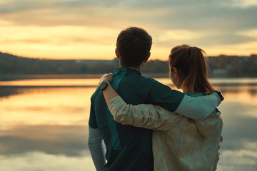 Happy romantic fit young couple enjoying sunset