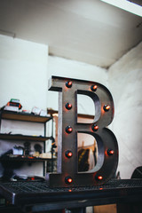 metal letter B with led light bulbs isolated on interesting background