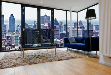 Modern living room with large windows and view on city panorama