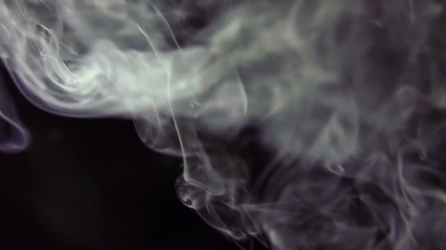 White Steam Rises from up. White smoke over a black background. Smoke slowly floating through space against black background. Slow Motion.