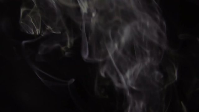 White Steam Rises from up. White smoke over a black background. Smoke slowly floating through space against black background. Slow Motion.