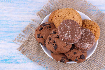 different cookies in a plate on a blue wooden table with a napkin. bake. yummy. view from above