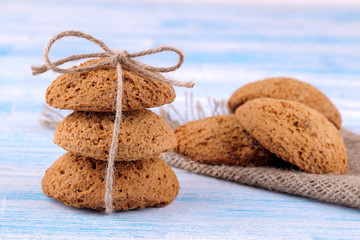 oatmeal cookies piled in the stack in the foreground on a blue wooden table with a napkin. bake. yummy.