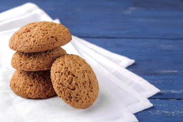 oatmeal cookies piled on a white napkin on a blue wooden table. bake. yummy.