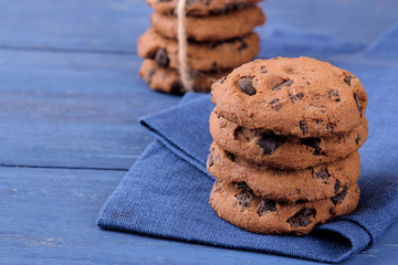 stacked chocolate cookies in stack on beautiful napkin on blue wooden table. bake. yummy