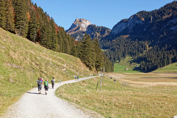 Fototapeta na wymiar Family hiking in sunny, last summer days, Appenzeller Sämtis valley with view of Hoher Kasten cable car station and aerial - Sämtis, Alpstein, Appenzell Alps, Switzerland