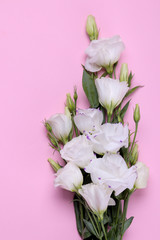 Beautiful white flowers. Eustoma bouquet on a bright pink background. view from above