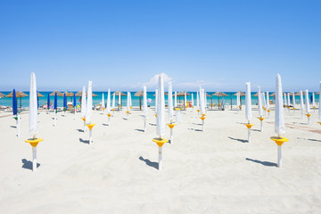 Alimini Grande, Apulia - Folded sunshades at the beautiful beach of Alimini Grande