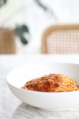 spaghetti Bolognese with minced beef and tomato sauce garnished with parmesan cheese and basil , Italian food