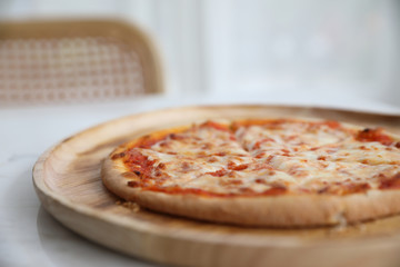 pizza margarita on wood dish in coffee shop background