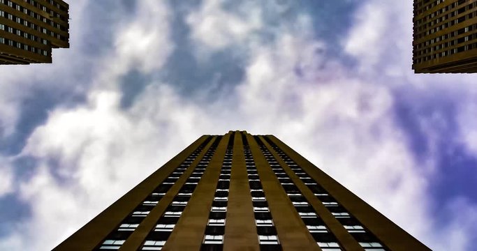 Dramatic timelaps of cloudy sunny day with building on the background. Brick residential building withclouds moving fast. Corporate Building, graay Sky and Clouds.