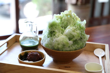 Delicious Japanese sweet shaved ice green tea on wooden table in japanese cafe - obrazy, fototapety, plakaty