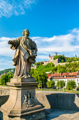 Fototapeta na wymiar Statue on the Alte Mainbrucke and Marienberg Fortress in Wurzburg, Germany