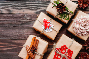 Christmas presents with hand made decorations - crocheted flower and snowflake, pine cones, cinnamon pods. DIY New Year decorations for wrapped in craft paper gifts.