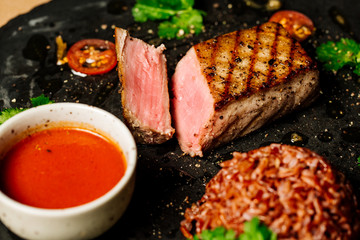 Tuna steak grilled and served with rice and sauce