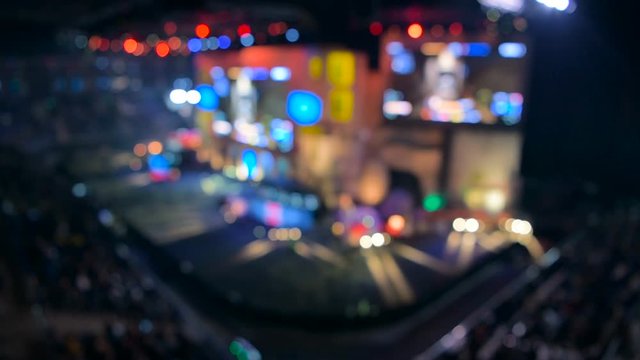 Esports event blurred backgroung. Main stage, lightning, illumination, big screen with game moments from overlooking spot at the top.