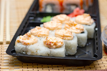 Delivery of Asian food home. Sushi rolls on a plastic plate. 