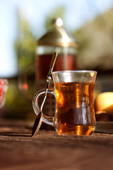 Autumn still life with tea cup on wooden planks and blur trees on background