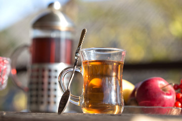 Autumn still life with tea cup on wooden planks and blur trees on background