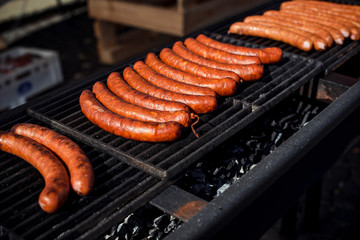 Grill sausages on on street food outdoor market. Fried baked sausages. European street food. Street food festival.