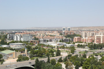 Fototapeta premium A landscape of Zaragoza city, with Ebro river shores, the Santiago bridge and the Actur district, a seen from the Pilar Catedral bell tower, Spain