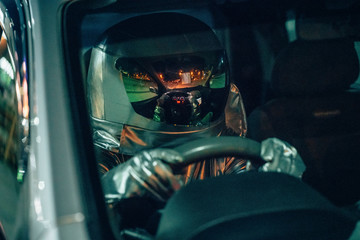 Spaceman driving car at night