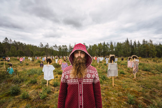 Finland, Suomussalmi, Man standing in front of The Silent People, art project with crowd of scare crows