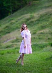 Beautiful girl in summer dress runs in the meadow.