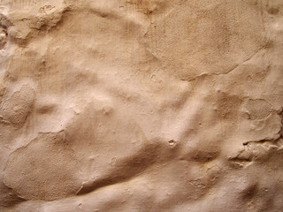 rough uneven terracotta colored cement wall background with paint brush marks texture