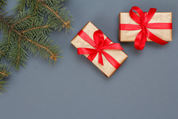Gift boxes and fir tree branches on gray background