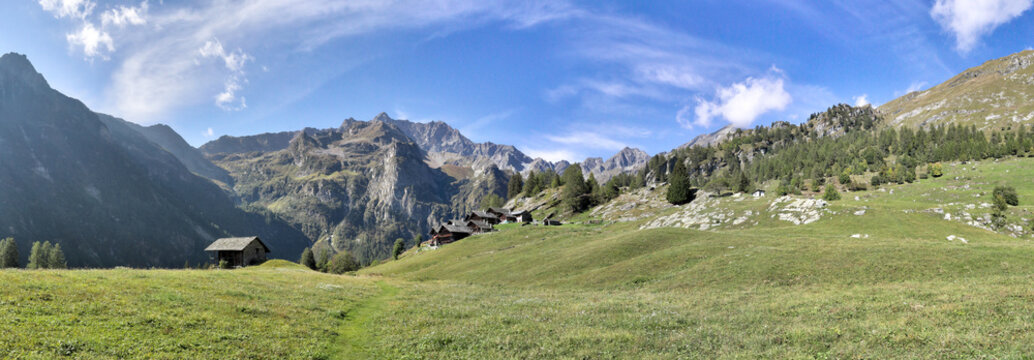 The Walser town of Follu, with wood and stone lodges, high mountains, forests and pastures, in summer, in Val d'Otro valley, Alps mountains, Italy