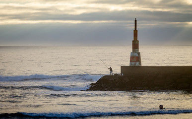 Fisherman near Beacon at the Ocean