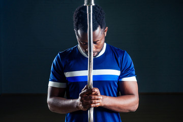 young african american man sportsman squatting sportsman exercising dumbbell T-shirt sports uniforms sport wear black background studio gym