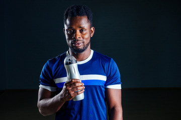 young african american man sportsman squatting sportsman exercising dumbbell T-shirt sports uniforms sport wear black background studio gym