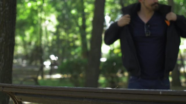 Male Walking through park sit down phone call