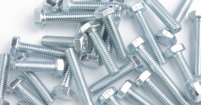 Stack of shiny screw, bolt or stud rotating on a white background