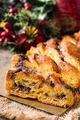 Homemade braid stuffed with chocolate and cut into pieces on wooden table. Close up	