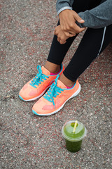 Detail of  running footwear and green detox smoothie. Fitness lifestyle and healthy nutrition concept.