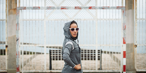 Motivated sporty woman on outdoor fitness workout break. Urban fitness lifestyle.