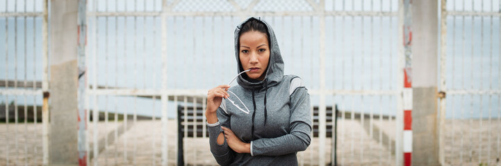 Banner of tough confident fitness woman portrait. Sporty urban latin looking serious and empowered at camera.